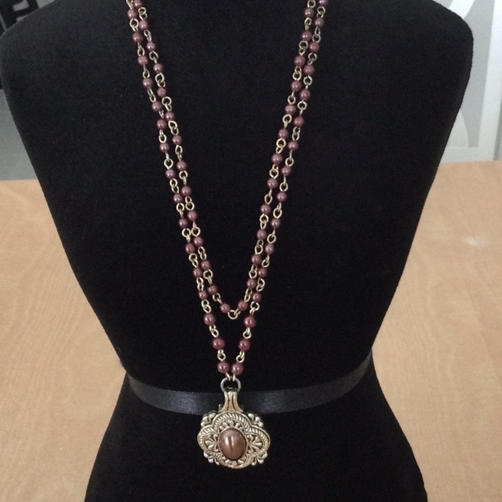 Woman’s Necklace Brown Beads on a gold color chain.